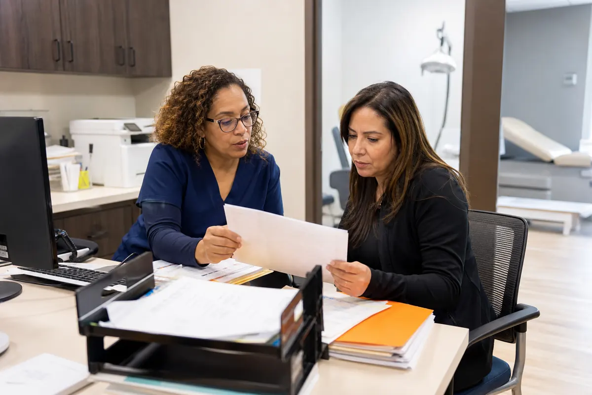 Dermatology practice manager and billing specialist reconciling charges and pathology
