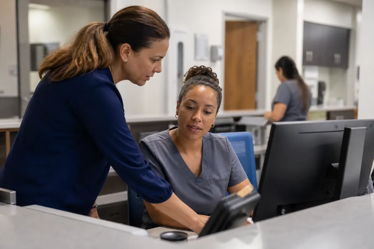 Practice manager coaching registration staff with an eligibility exception checklist