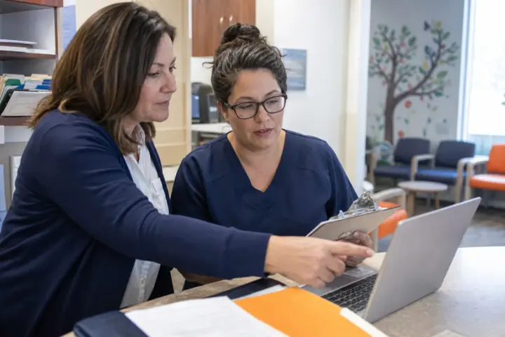 Pediatric practice manager and billing specialist reviewing coverage workflow
